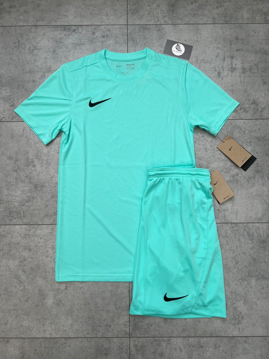 Flat-lay image of a brand new Nike Dri Fit Short & T-shirt Set in Hyper Turquoise. The set includes a slim-fit t-shirt and matching shorts with black Nike swoosh logos, displayed on a grey tiled background with product tags visible.