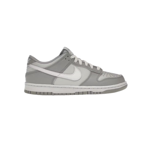 Side view of Nike Dunk Low GS ‘Two-Toned Grey’ featuring light and dark grey leather overlays with white swoosh and midsole, displayed on a white background.